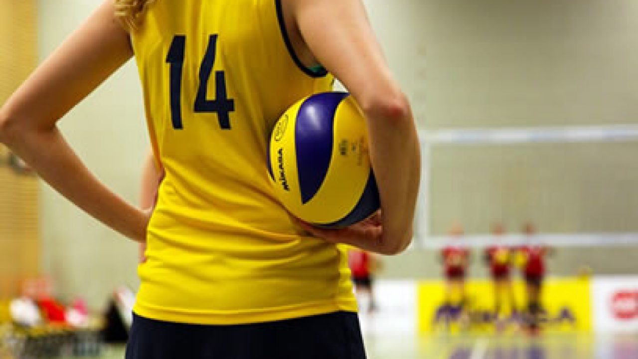 Jogador de voleibol com bola na quadra de vôlei